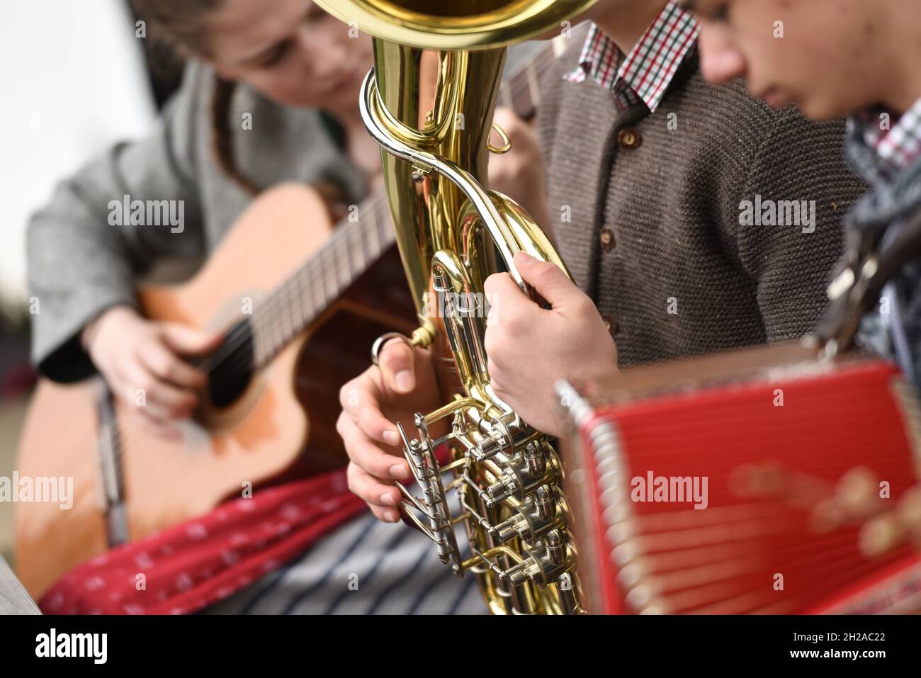 Drei junge Menschen spielen Volksmusik. - Three young people play folk music. Stock Photo