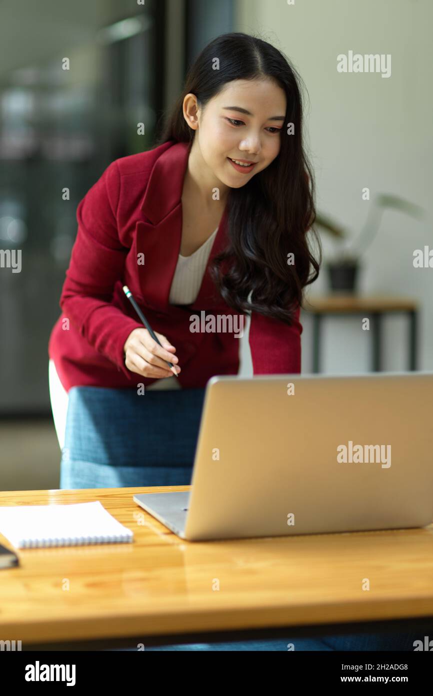 Beautiful business woman standing in the office and working on her ...