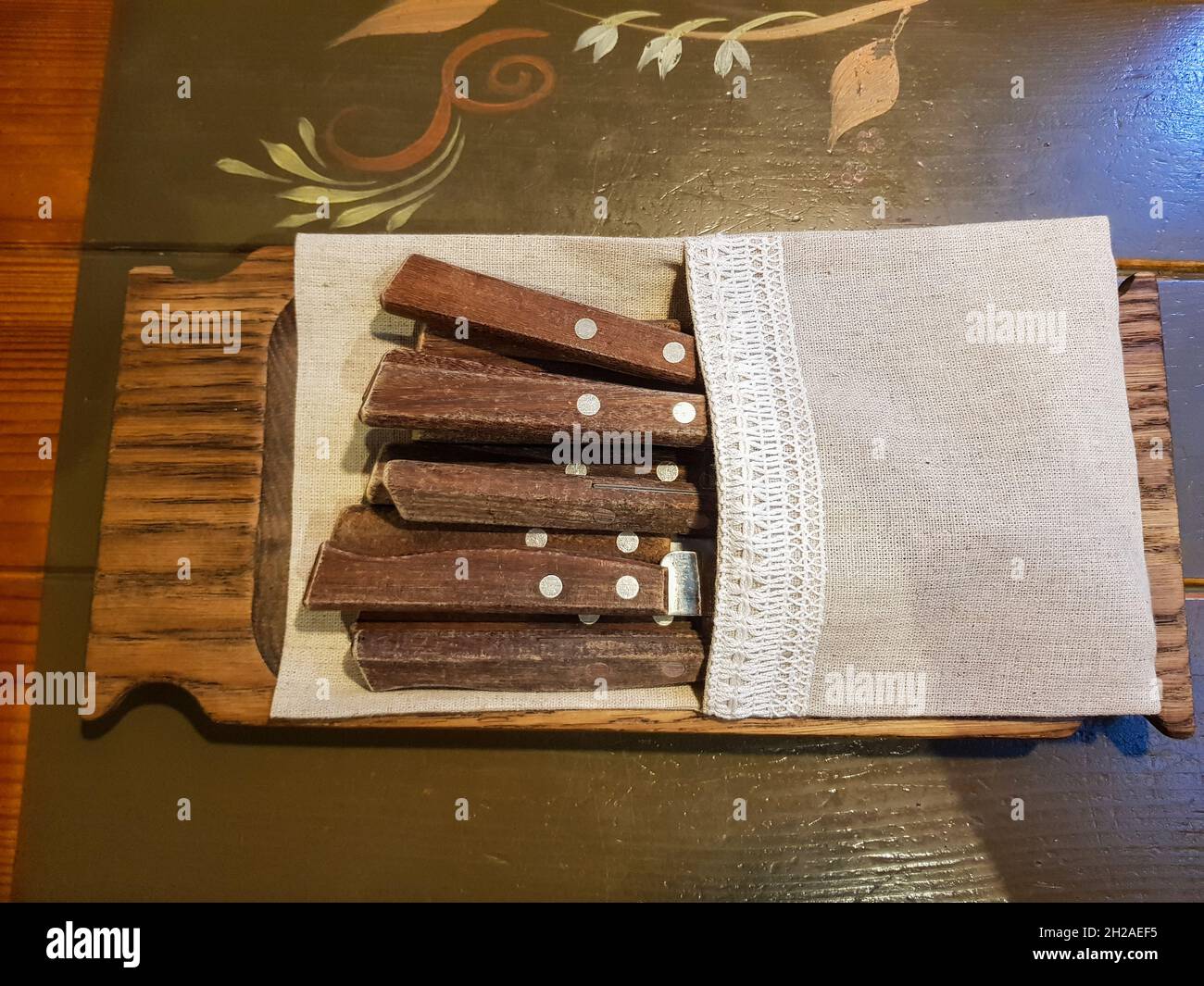 forks and knives with wooden handles are on the table in the restaurant