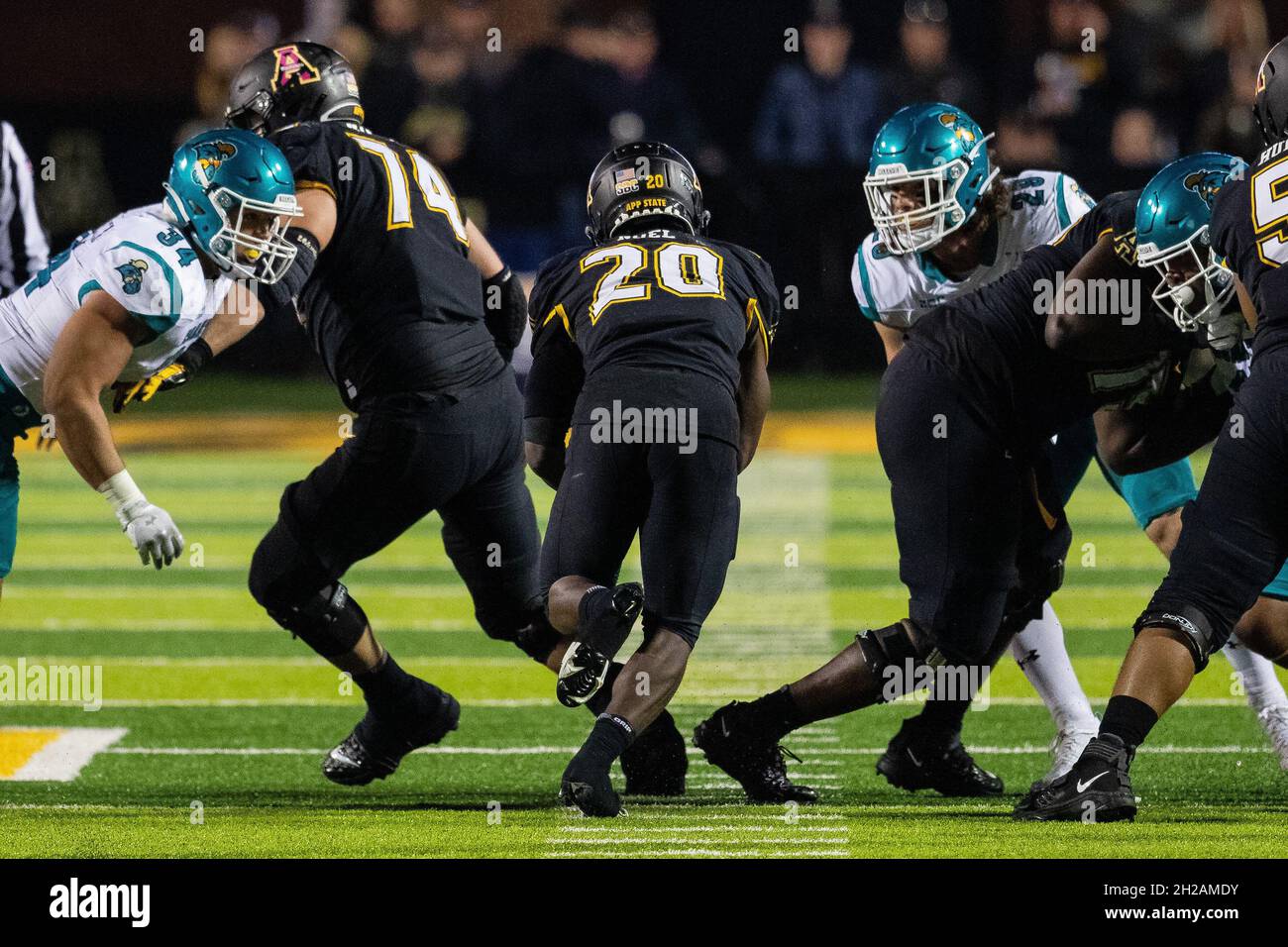 Boone, NC, USA. 20th Oct, 2021. Appalachian State Mountaineers running back Nate Noel (20) squeezes through a hole against the Coastal Carolina Chanticleers in the third quarter of the Sun Belt Conference matchup at Kidd Brewer Stadium in Boone, NC. (Scott Kinser/Cal Sport Media). Credit: csm/Alamy Live News Stock Photo