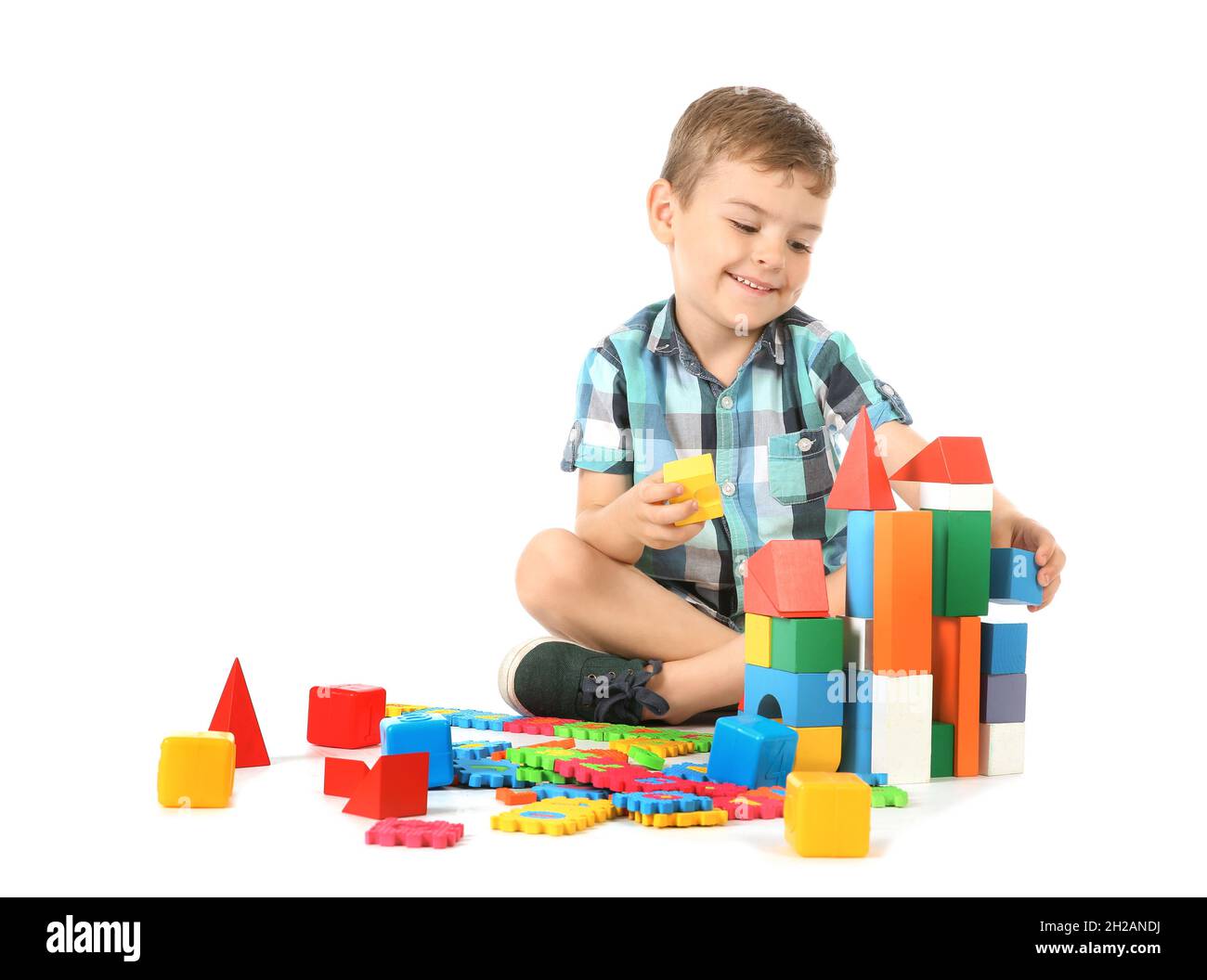 Little child playing with blocks on white background. Indoor recreation