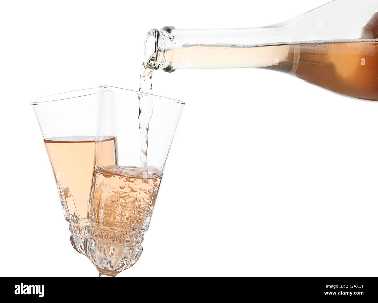 Pouring rose champagne from bottle into glass on white background Stock ...