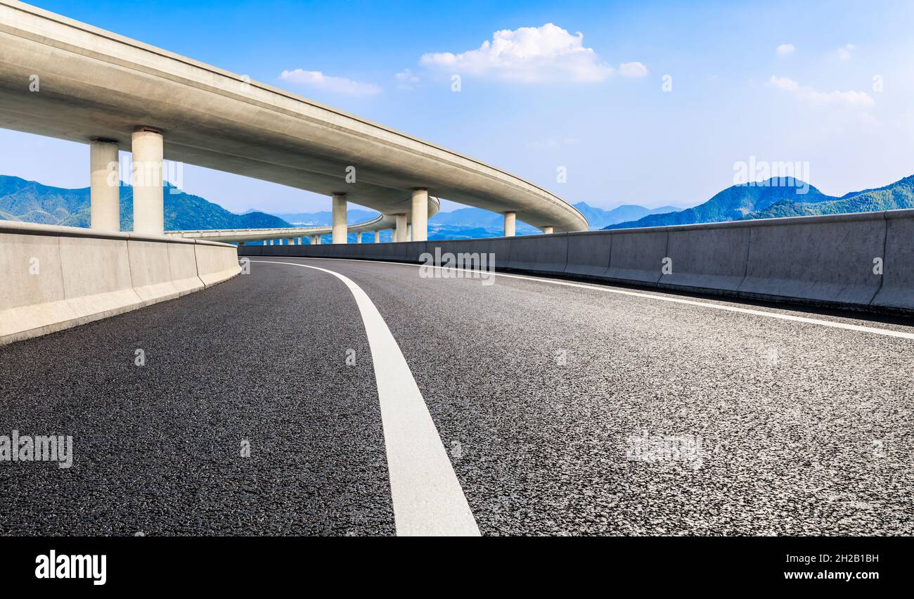Asphalt road and mountain under the blue sky Stock Photo - Alamy