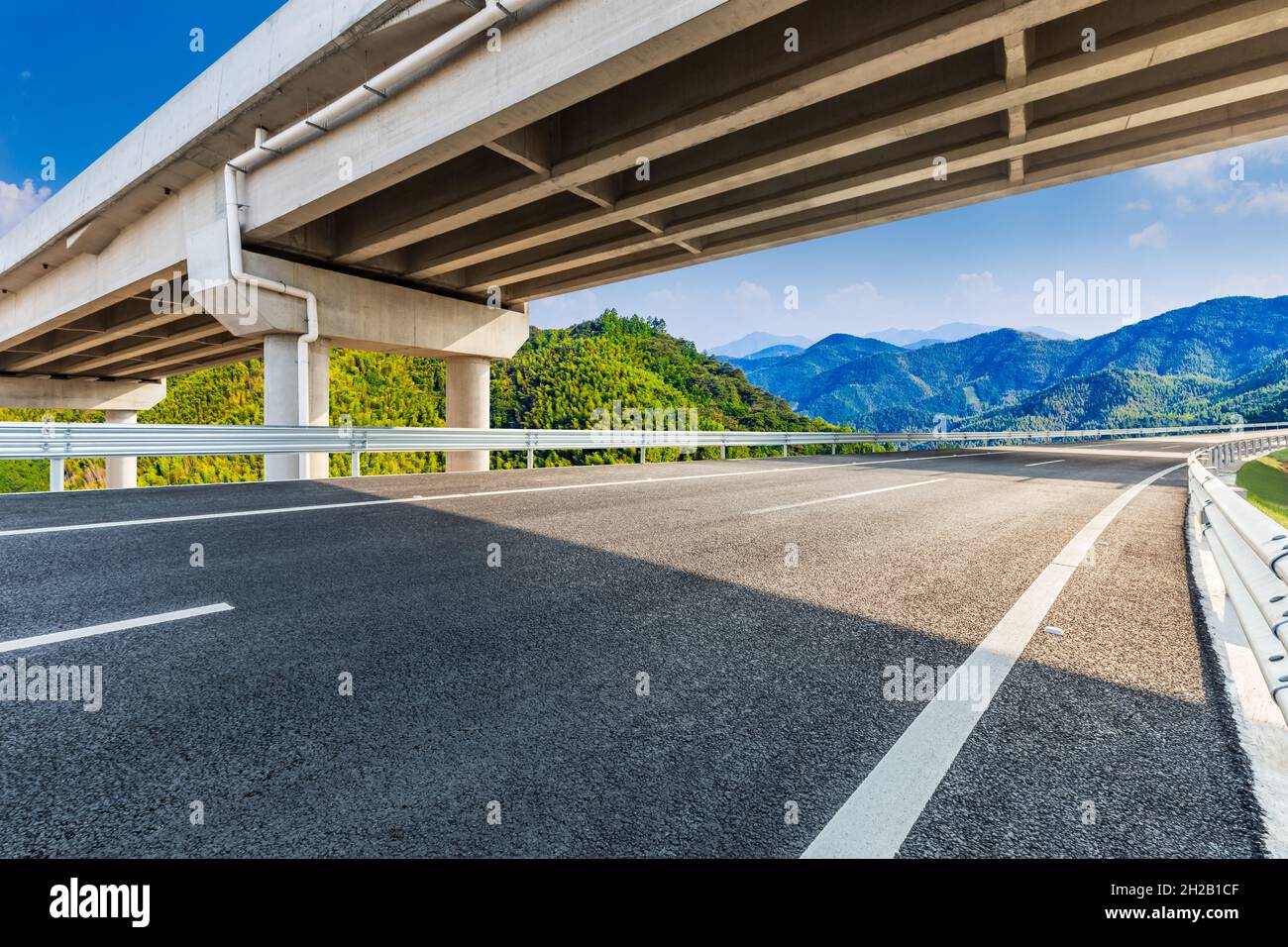 Asphalt road and mountain under the blue sky Stock Photo - Alamy