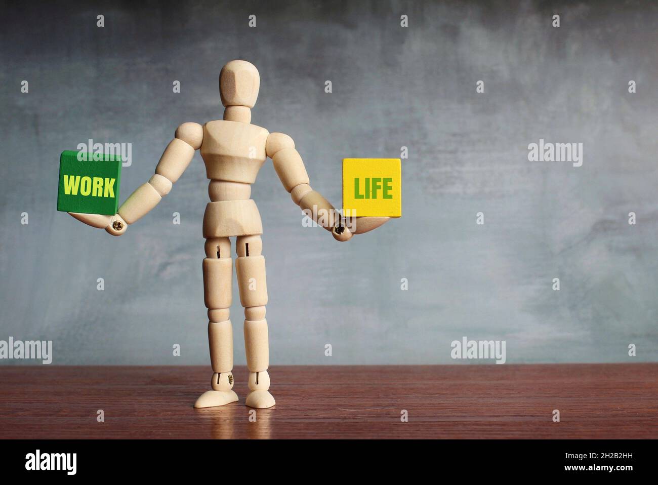 Work life balance concept. Wooden human figure balancing two wooden ...