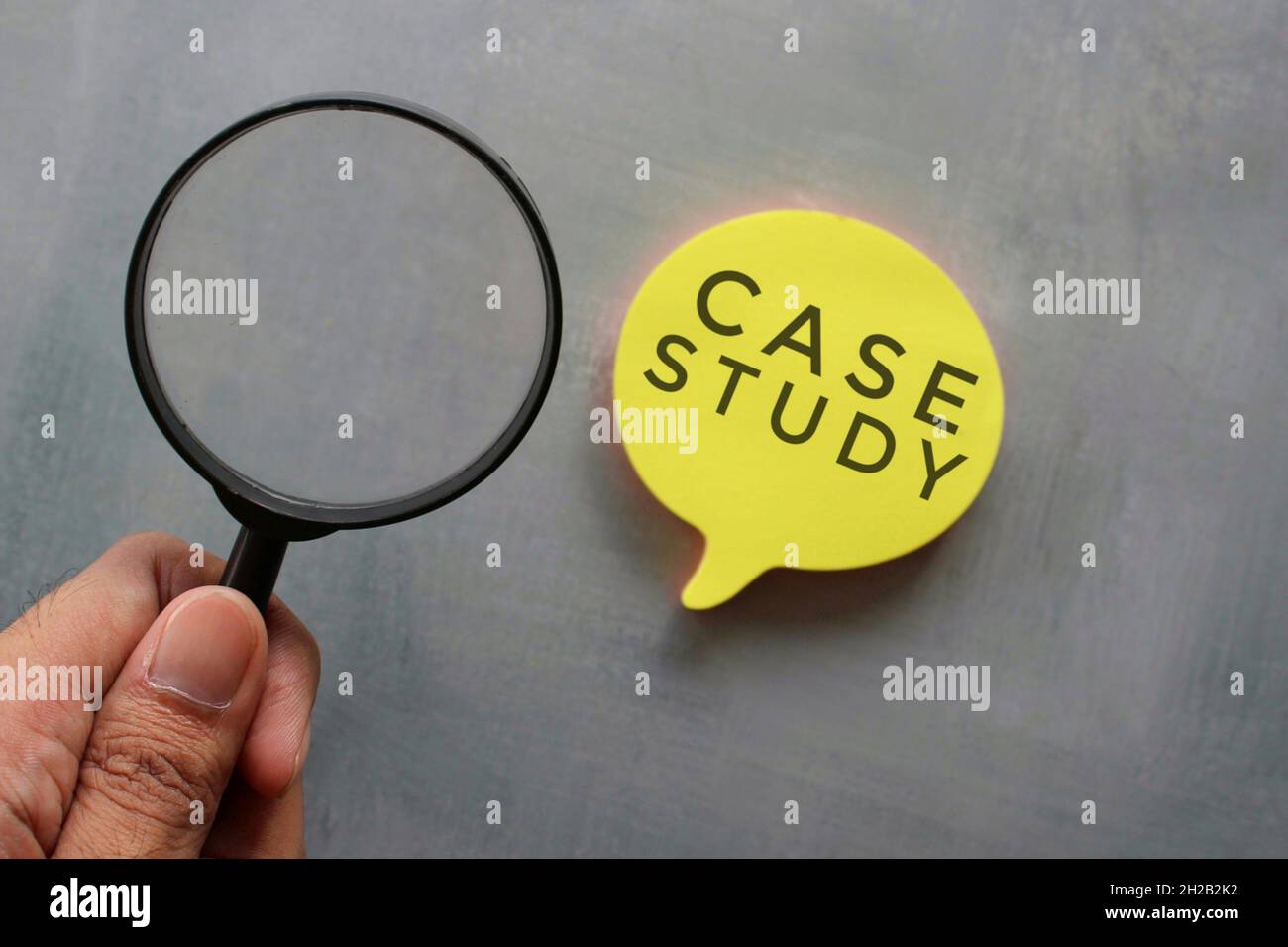 Case study concept. Hand holding magnifying glass and bubble speech with text CASE STUDY. Stock Photo