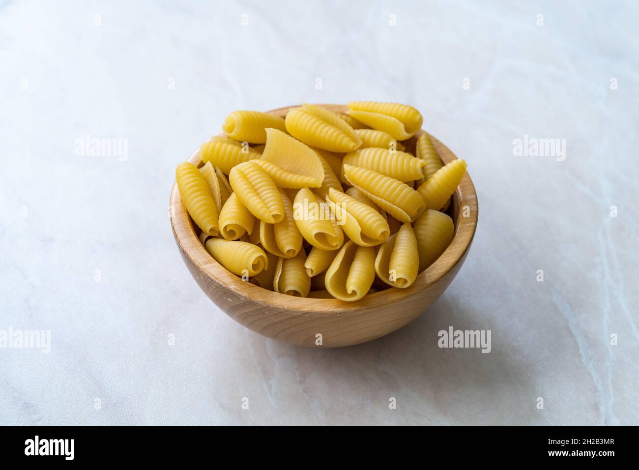 https://c8.alamy.com/comp/2H2B3MR/homemade-dry-organic-raw-cavatelli-pasta-in-wooden-bowl-ready-to-cook-2H2B3MR.jpg