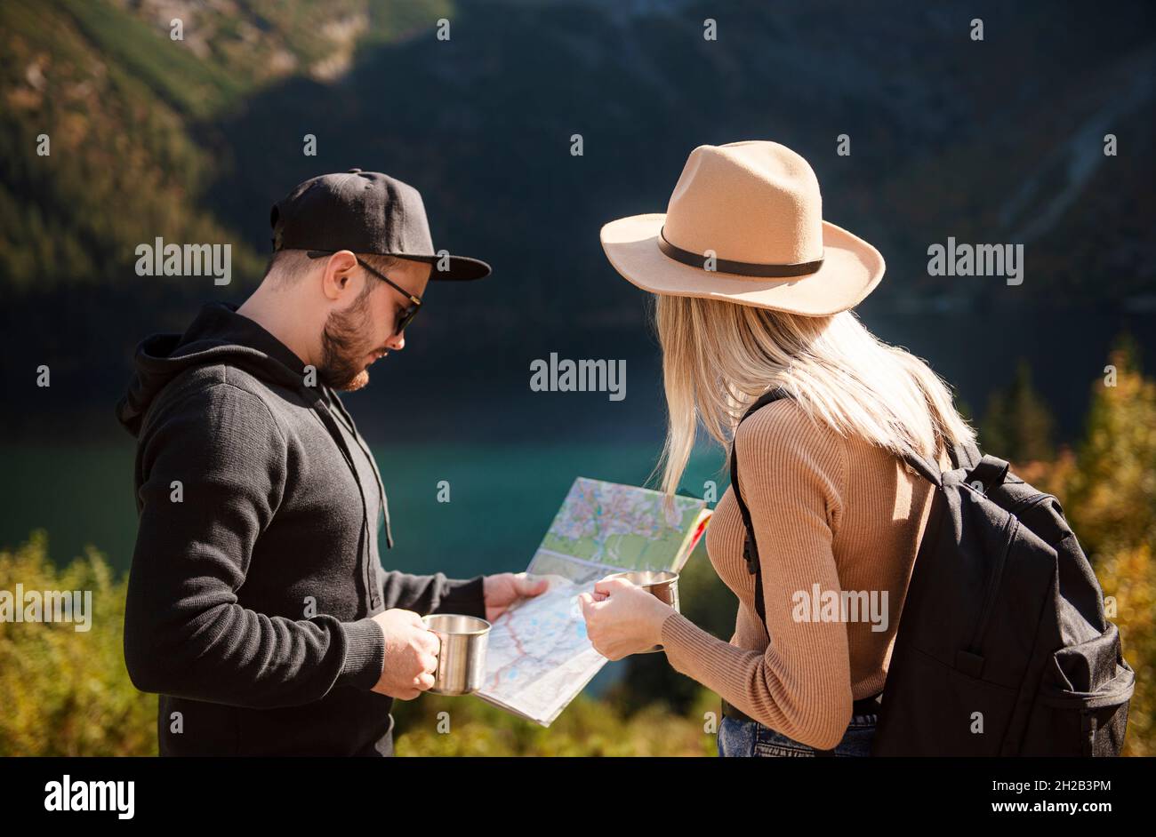 Young tourist couple, man and woman, on hiking path in mountains ...