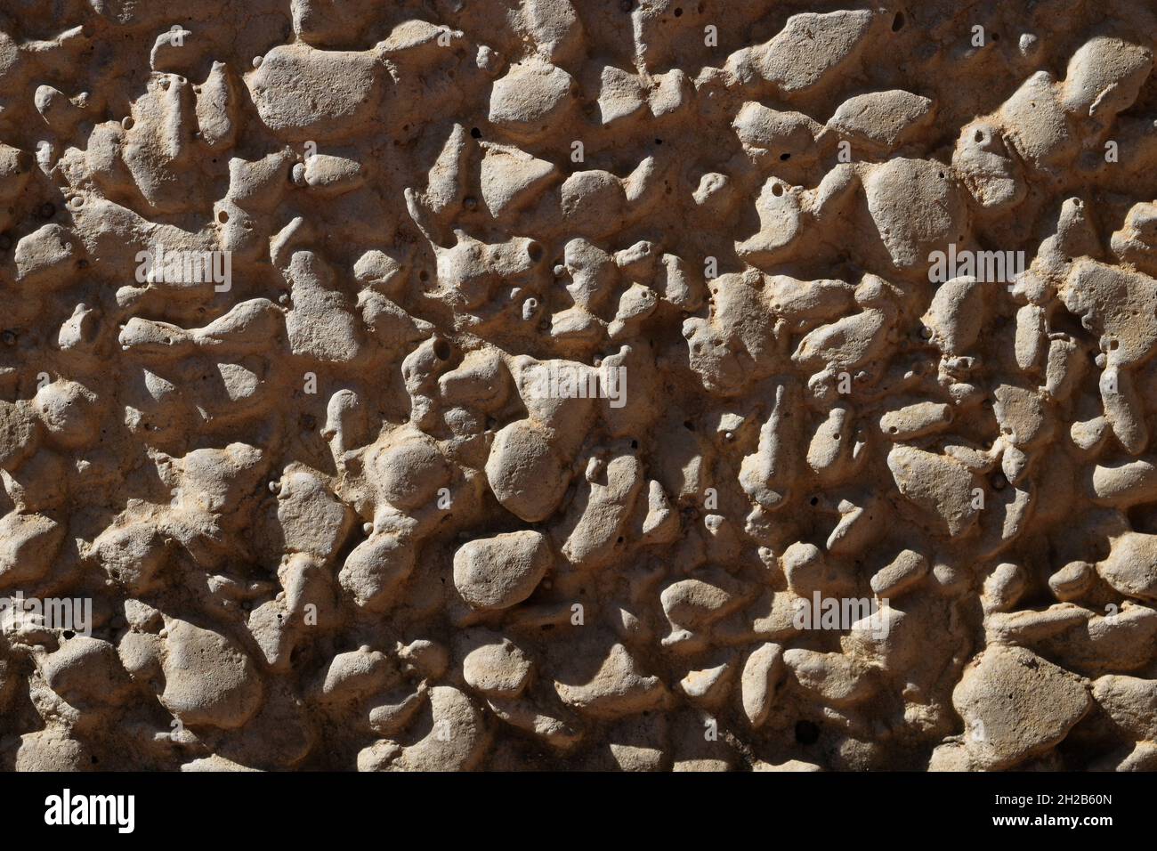 Background close up of an exposed aggregate concrete wall slab with pebbles. Background, abstract, construction concept. Stock Photo