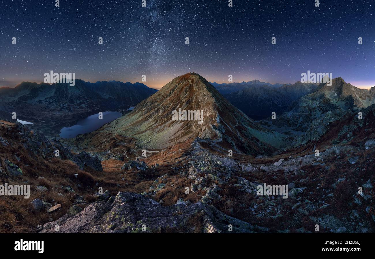 A beautiful starry night in the mountains on top with beautiful scenery and fog. Stock Photo