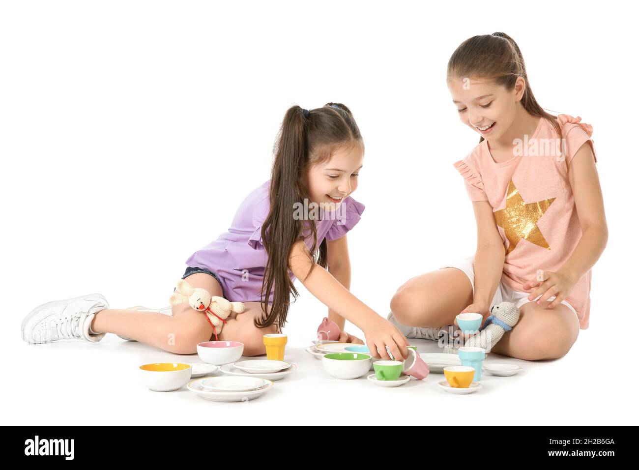Little children playing tea party with toys on white background. Indoor ...