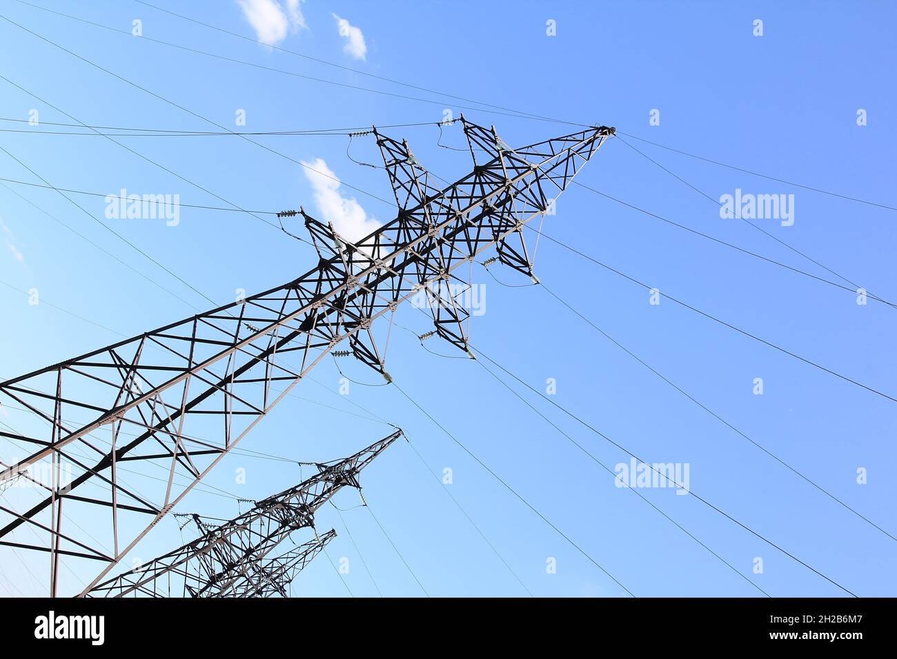 Electric transmission line on blue sky background Stock Photo