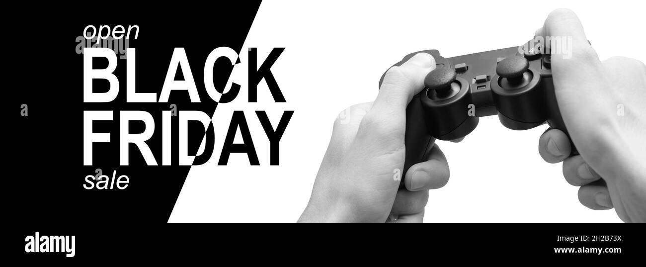 Gamer holding controller joystick on hands and play game with background laptop screen , e-sport concept, black and white background text black friday Stock Photo