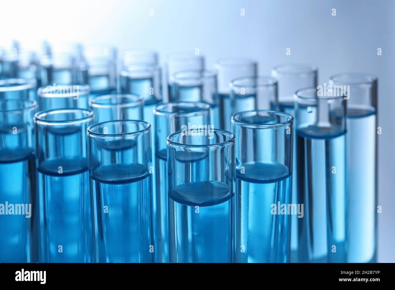 Test tubes with liquid against color background, closeup. Laboratory ...