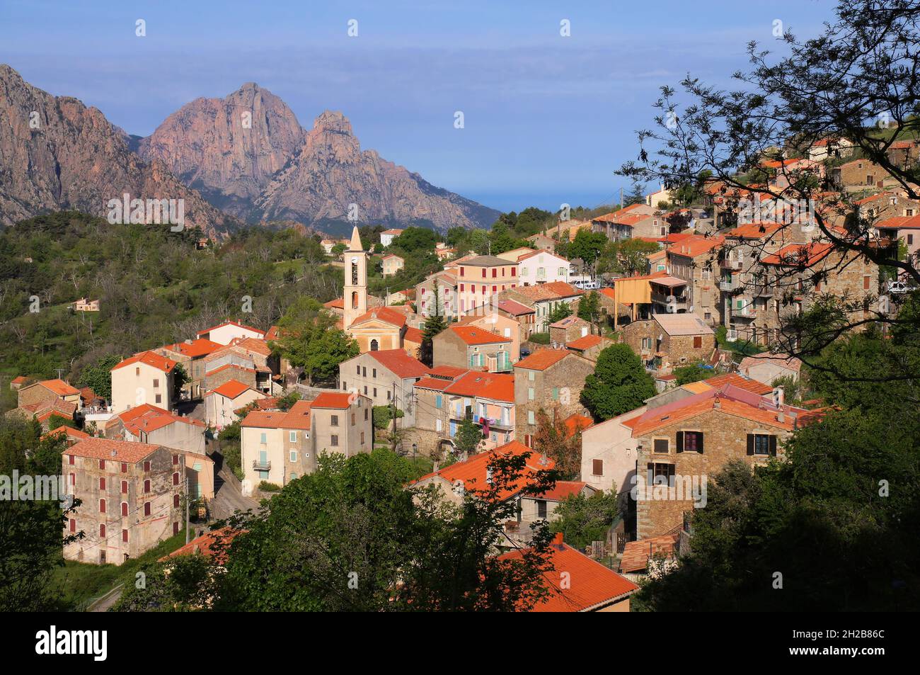 View of mountains, town and the sea soon after sunrise in Evisa, Corsica, France Stock Photo