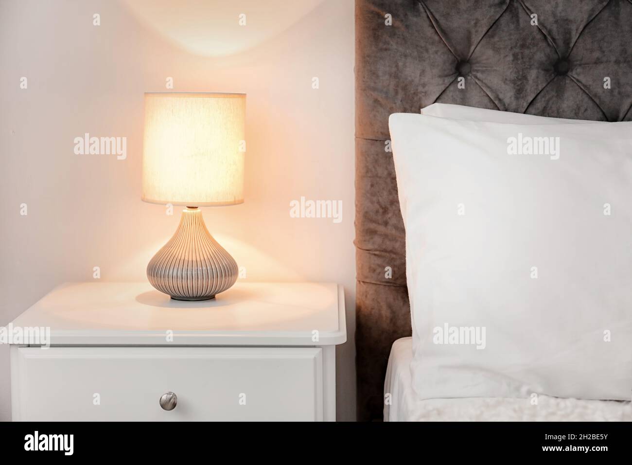 Lamp on bedside table in modern hotel room Stock Photo Alamy