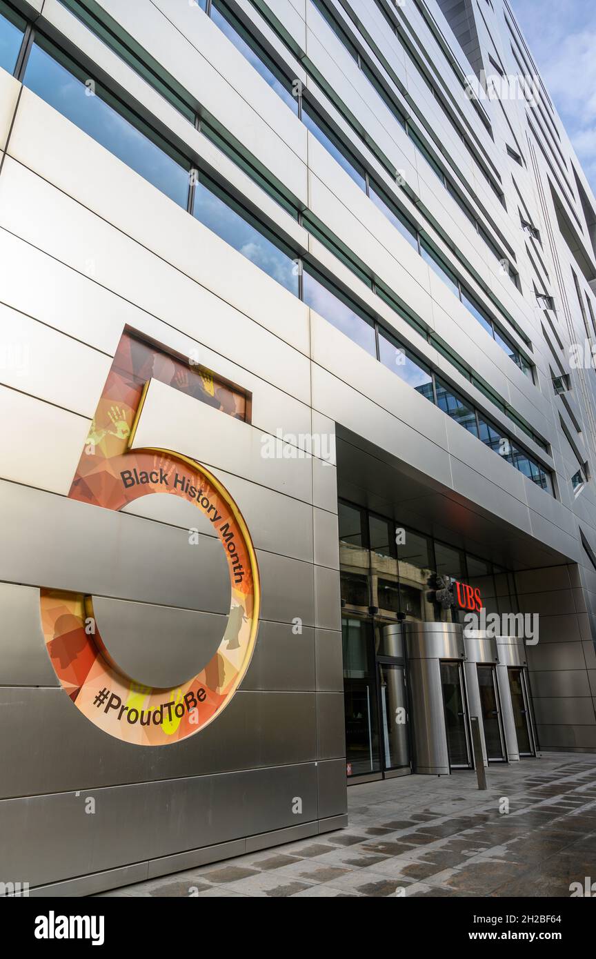 Facade and entrance to UBS AG bank's office block at 5 Broadgate. Debossed number 5 has Black History Month artwork inserted. City of London, England. Stock Photo