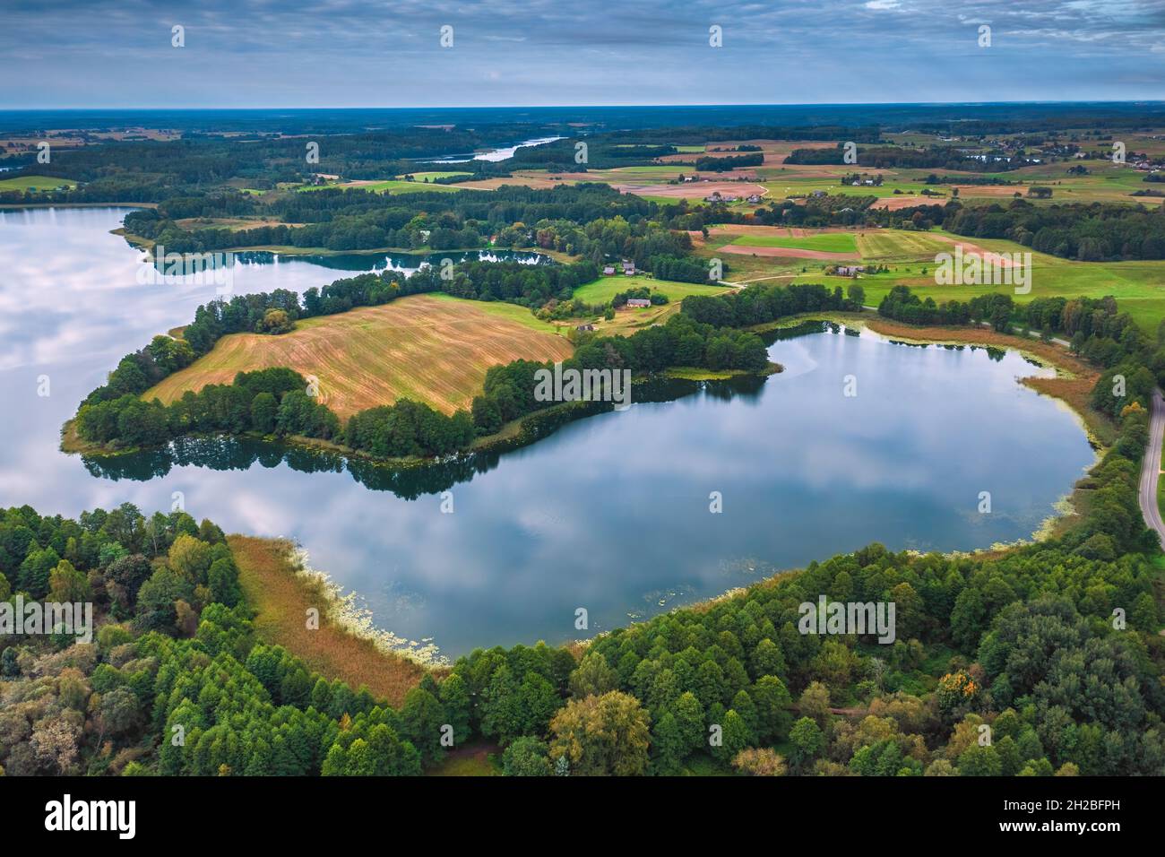 Aerial view of Ancia lake in Lithuania, shiny reflection of sky with clouds in the water of the lake Stock Photo