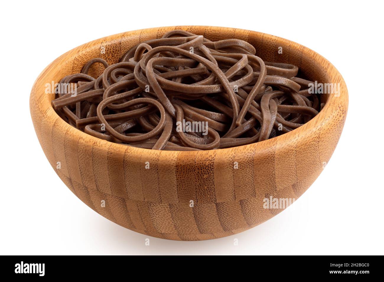 Cooked soba noodles in a bamboo bowl isolated on white. Stock Photo