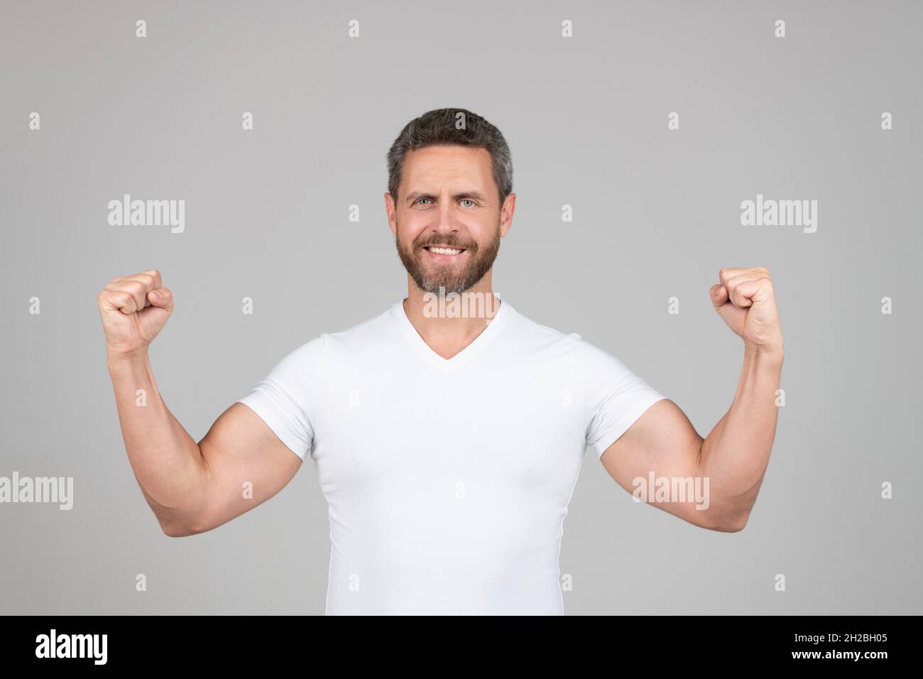 I am strong. Strong man grey background. Fit guy show strength. Muscle flexing. Physical fitness Stock Photo