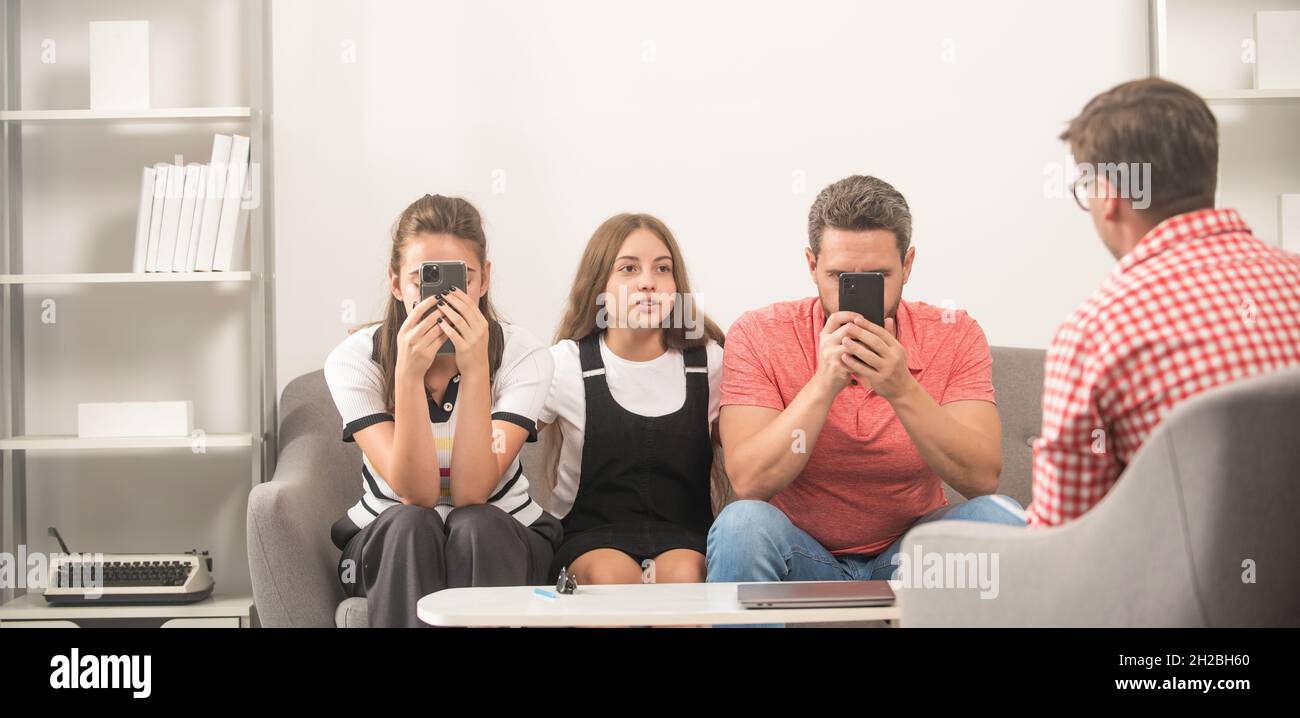 phone addicted father mother and child at family psychologist, communication Stock Photo
