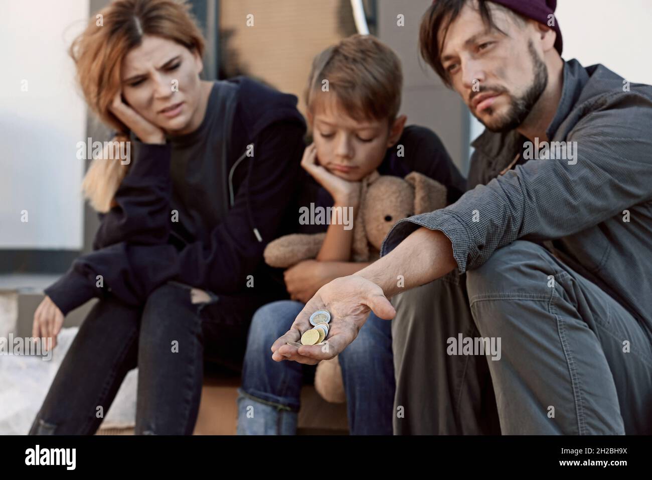 Poor homeless family begging on city street Stock Photo - Alamy