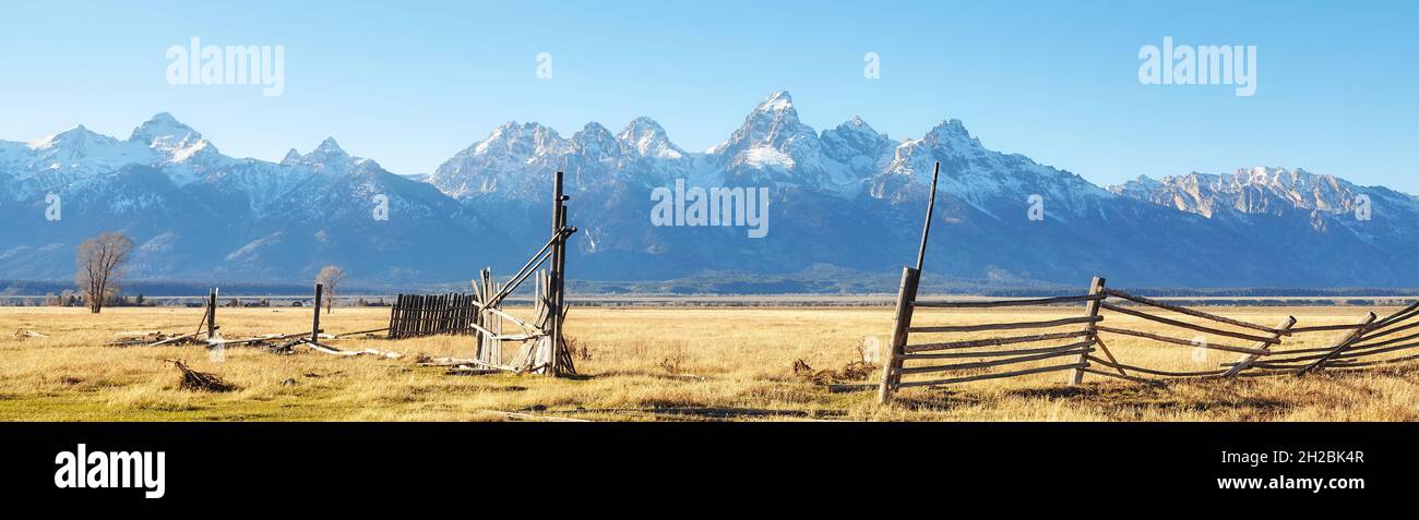 Old broken wooden fence on a field with Teton mountain range in background, Wyoming, USA. Stock Photo