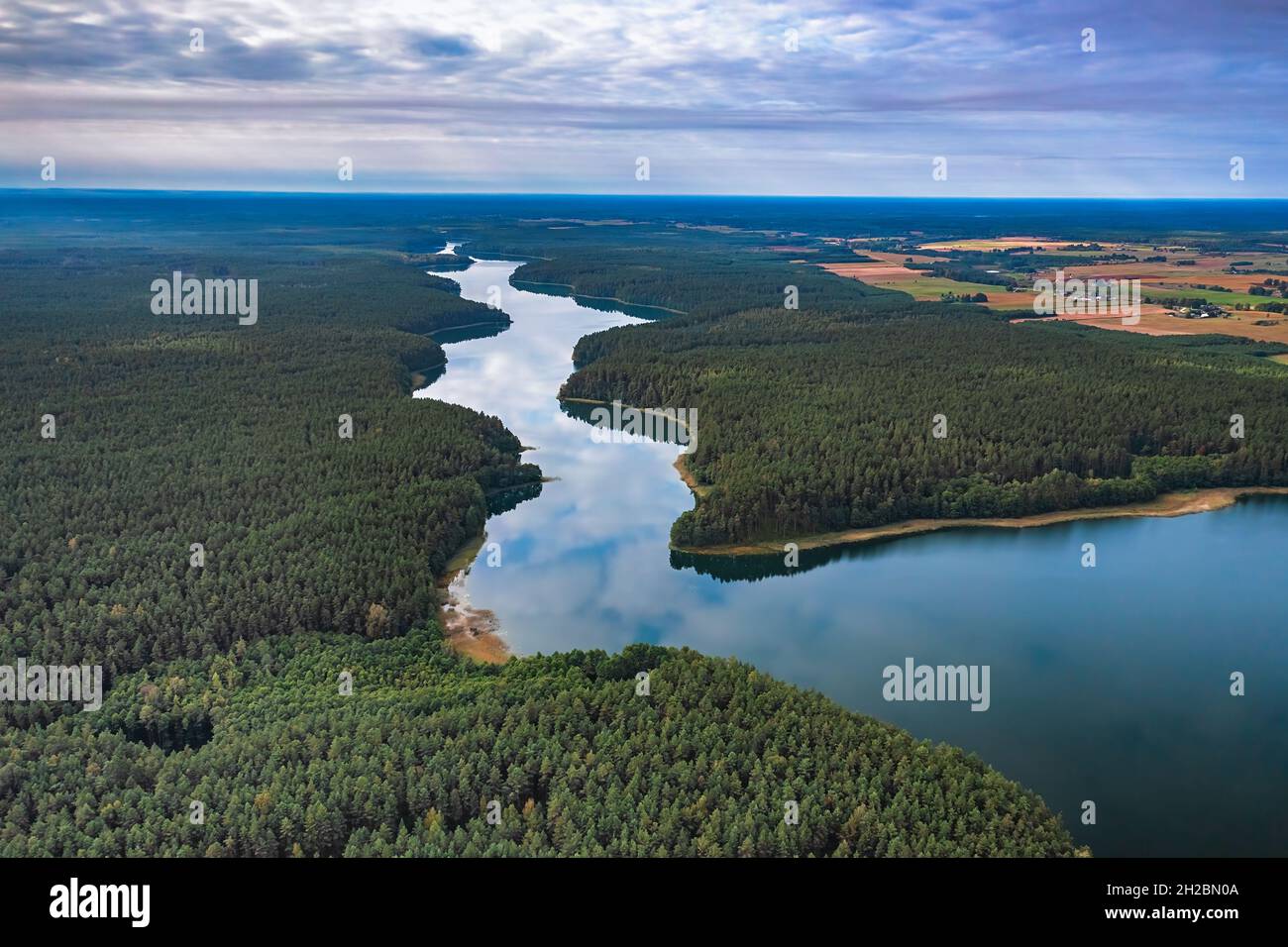 Aerial view of Ancia lake in Lithuania, shiny reflection of sky with clouds in the water of the lake Stock Photo
