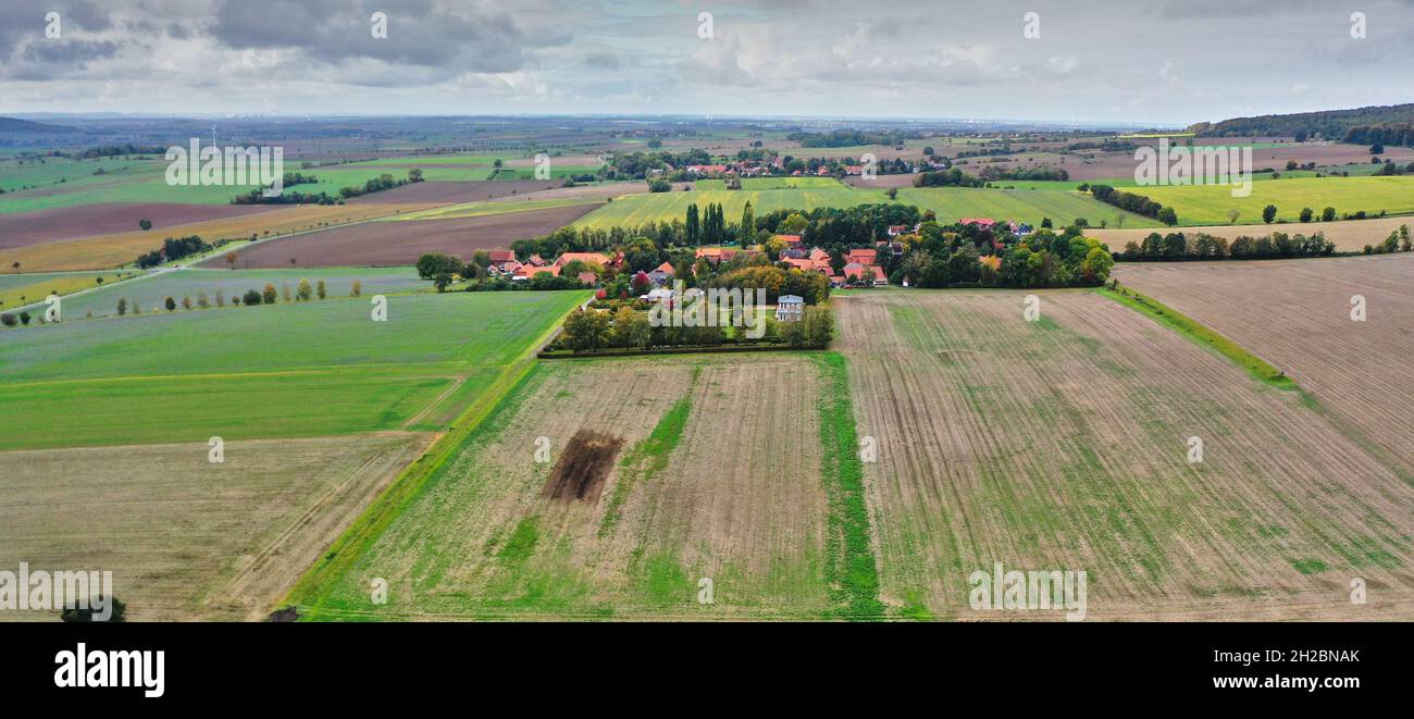 Aerial view of a small village at the edge of the Elm in Lower Saxony, Germany, with agricultural land in front of it Stock Photo