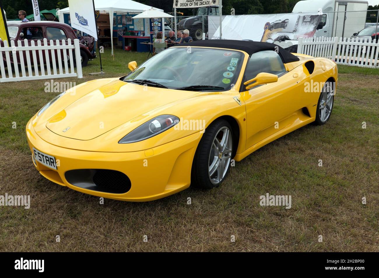 Three-quarter front view of a Yellow, 2006, Ferrari F430 Spyder, on display at the 2021 London Classic Car Show Stock Photo