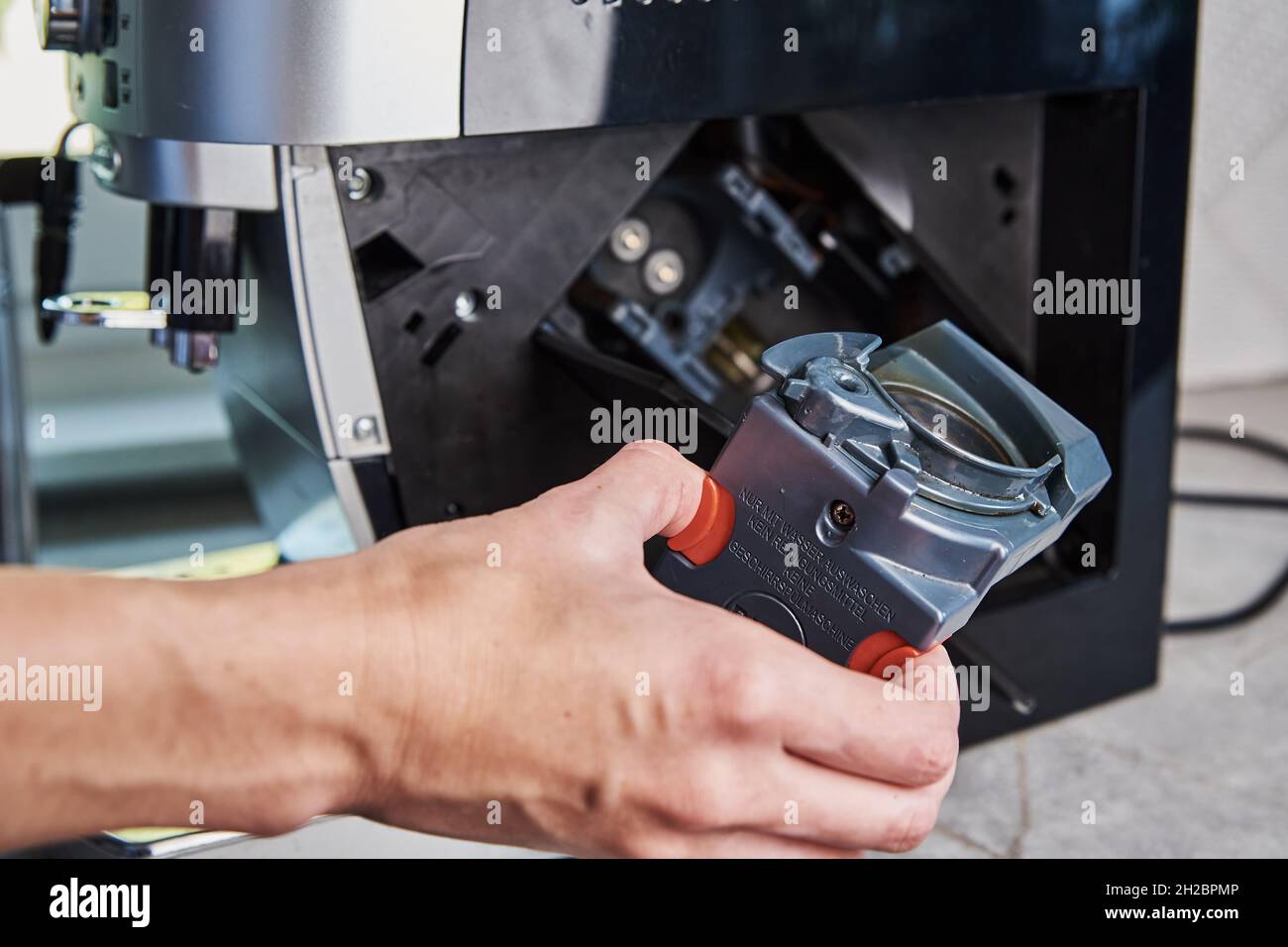 Automatic coffee machine cleaning. Woman inserts mechanism inside