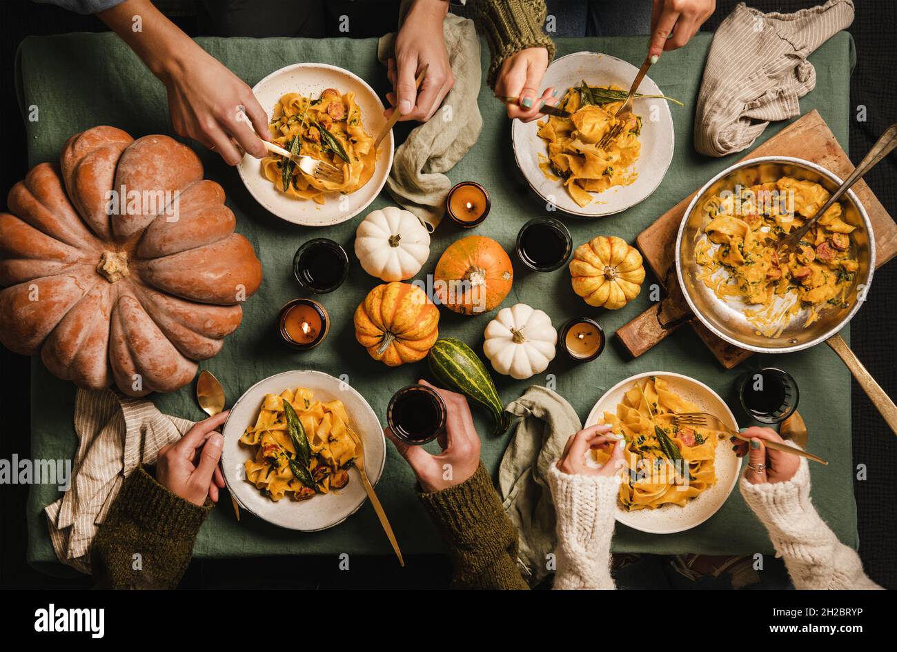 People eating squash pasta with sausage on Thanksgiving day Stock Photo