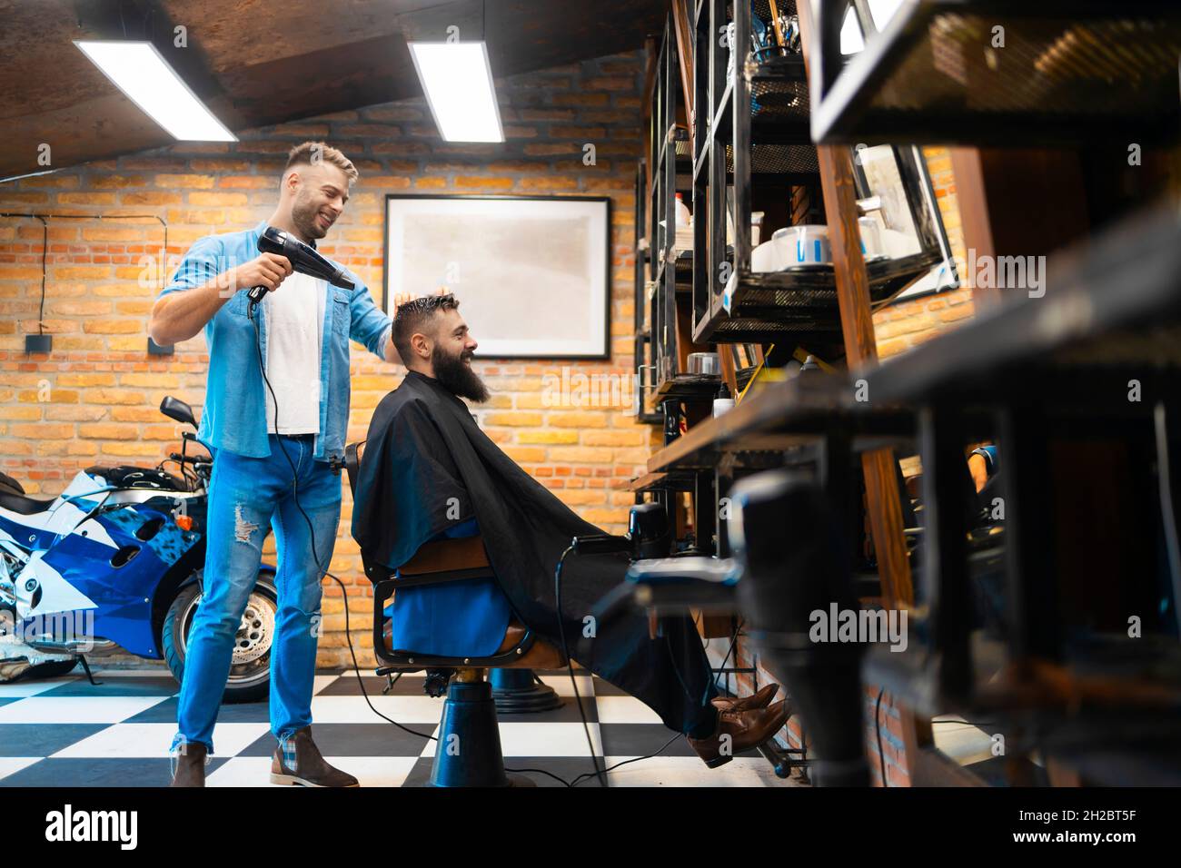 Male hairstylist drying his customers hair Stock Photo