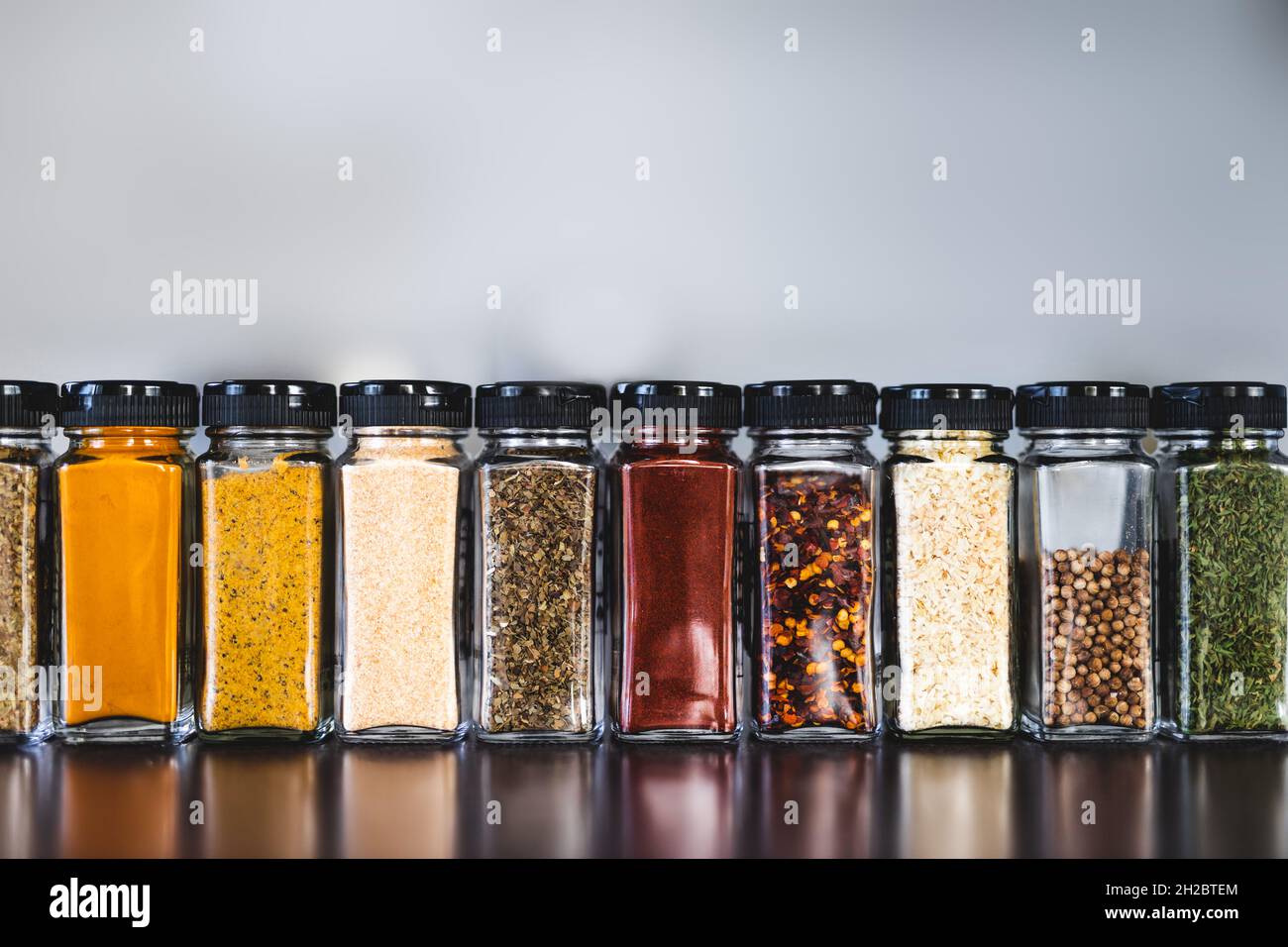spices seeds and seasonings in matching spice jars on tidy pantry shelf