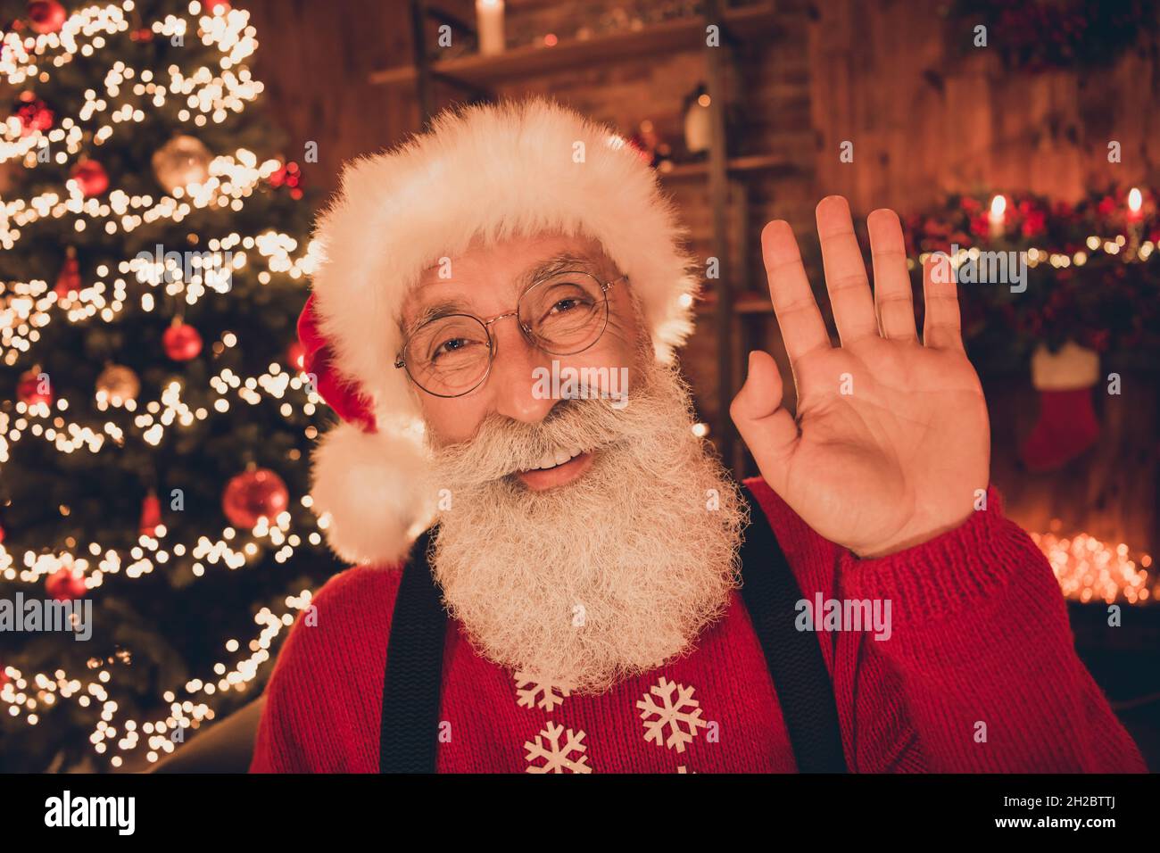 Portrait of attractive cheerful Santa waving hello congrats eve party ...