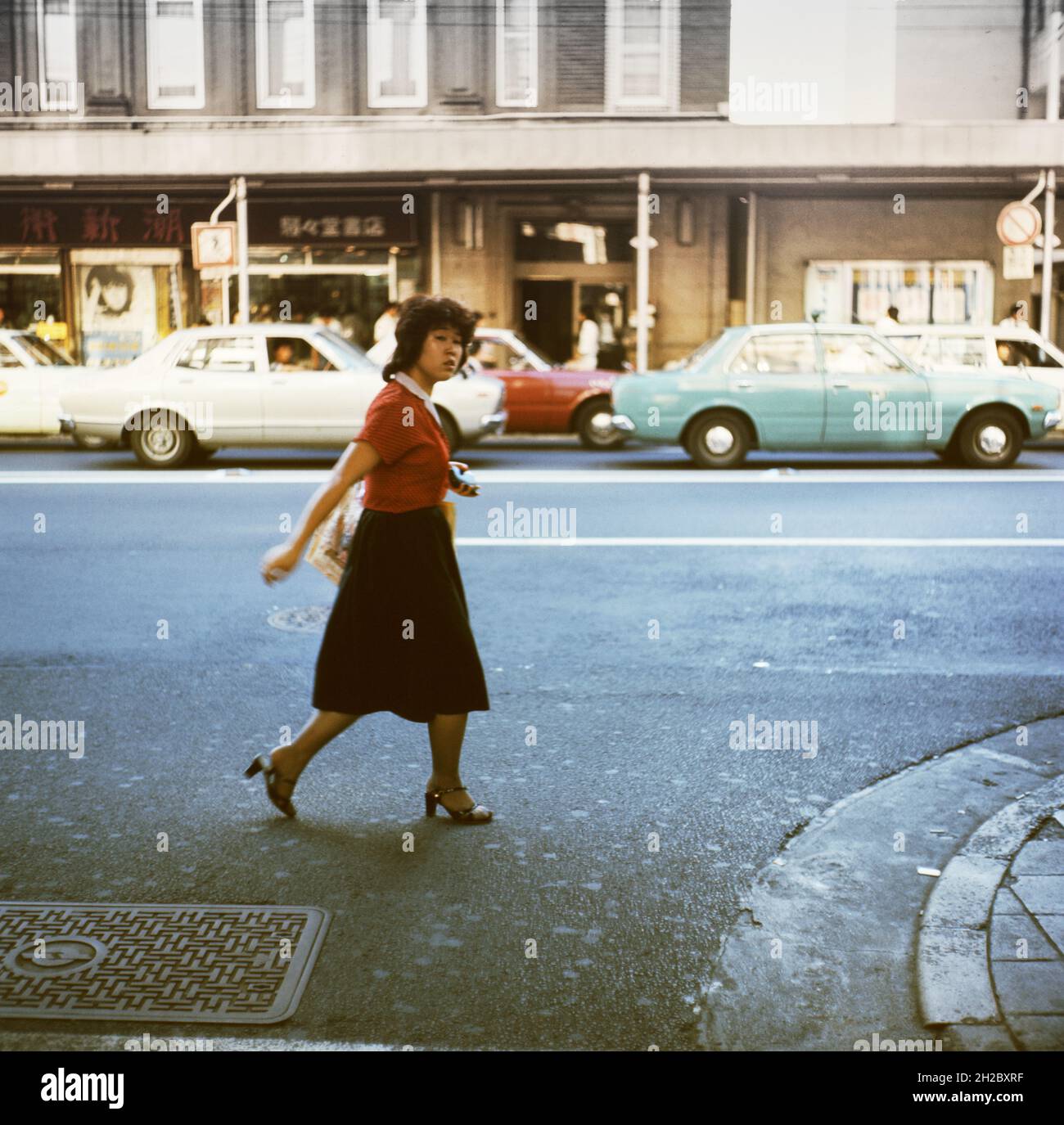 A young woman walks down the street. Japan, 1970s Stock Photo