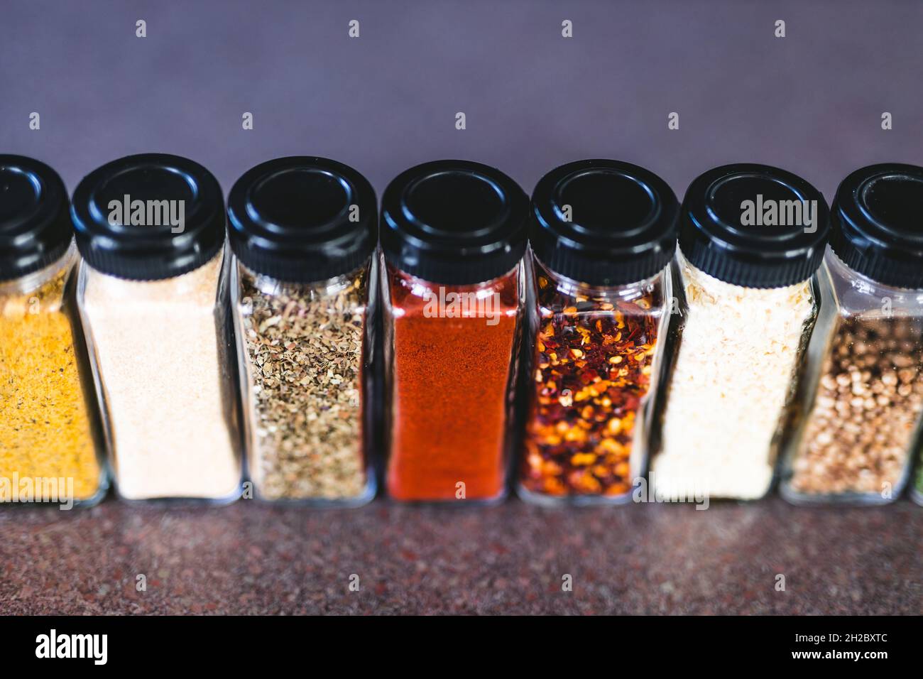 spices seeds and seasonings in matching spice jars on tidy pantry shelf