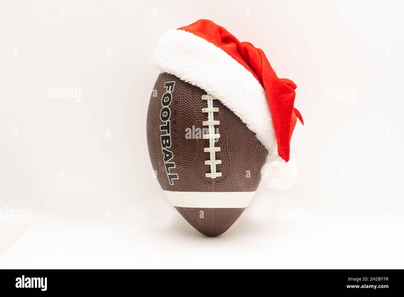 Santa hat with rugby ball on white background Stock Photo - Alamy