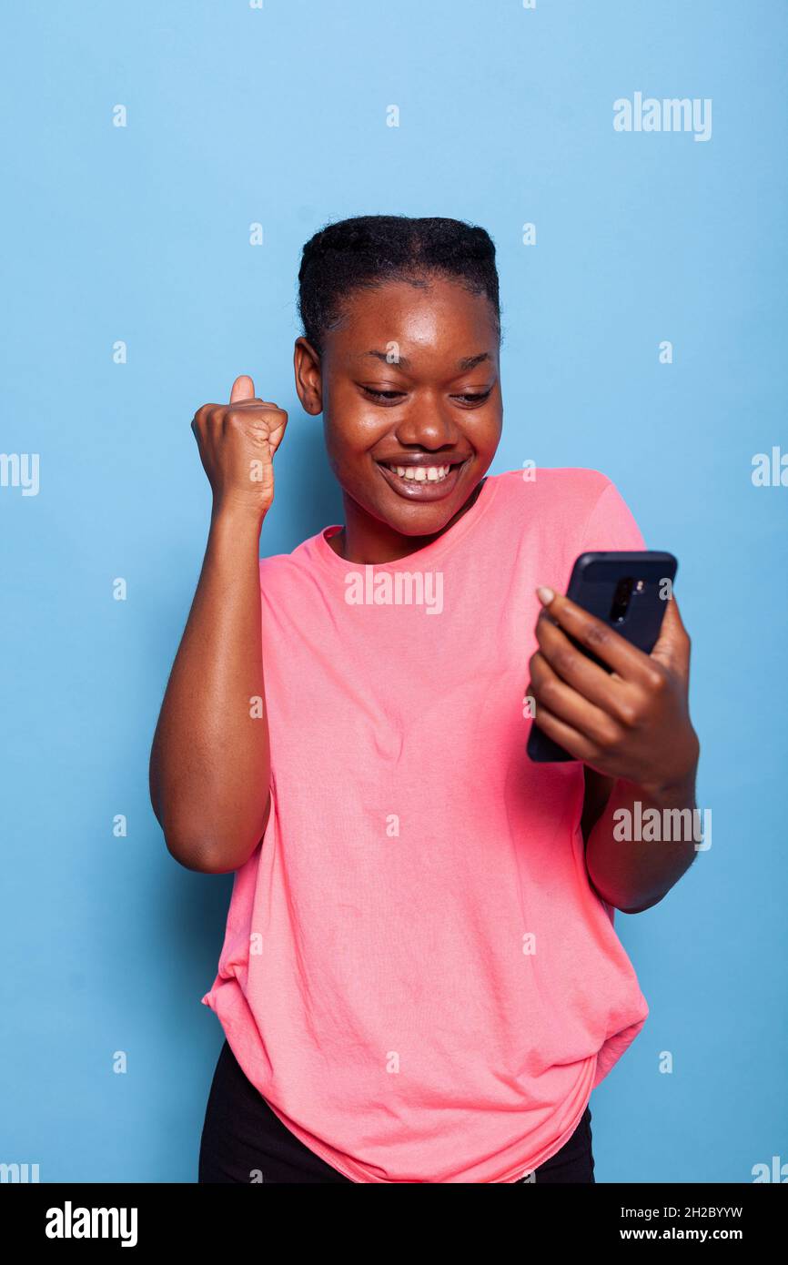 Portrait of happy african american young woman received a message from ...