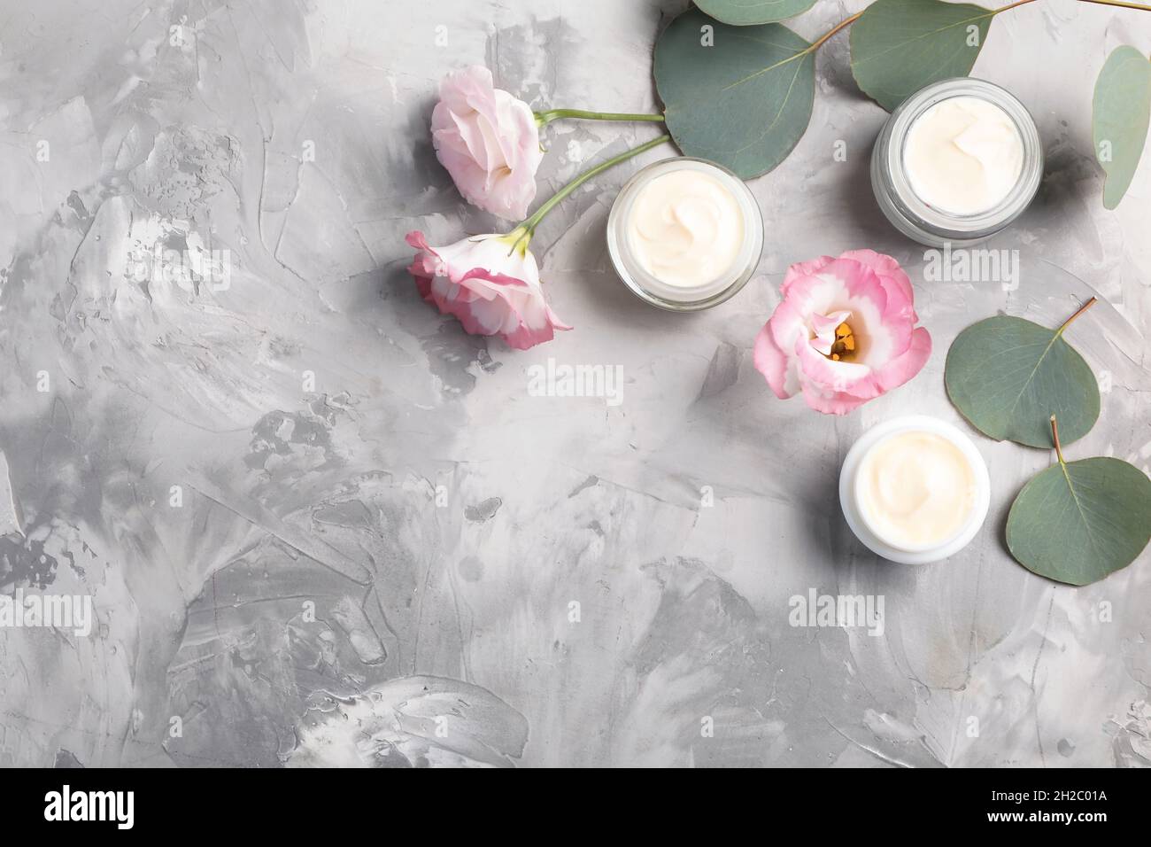 Flat lay composition with hand cream jars and space for text on gray ...