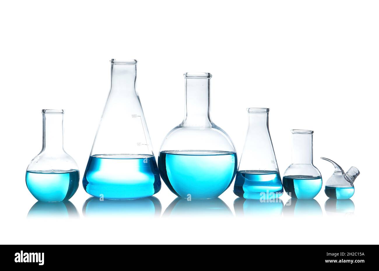 Laboratory glassware for chemical analysis with blue liquid on table against white background Stock Photo