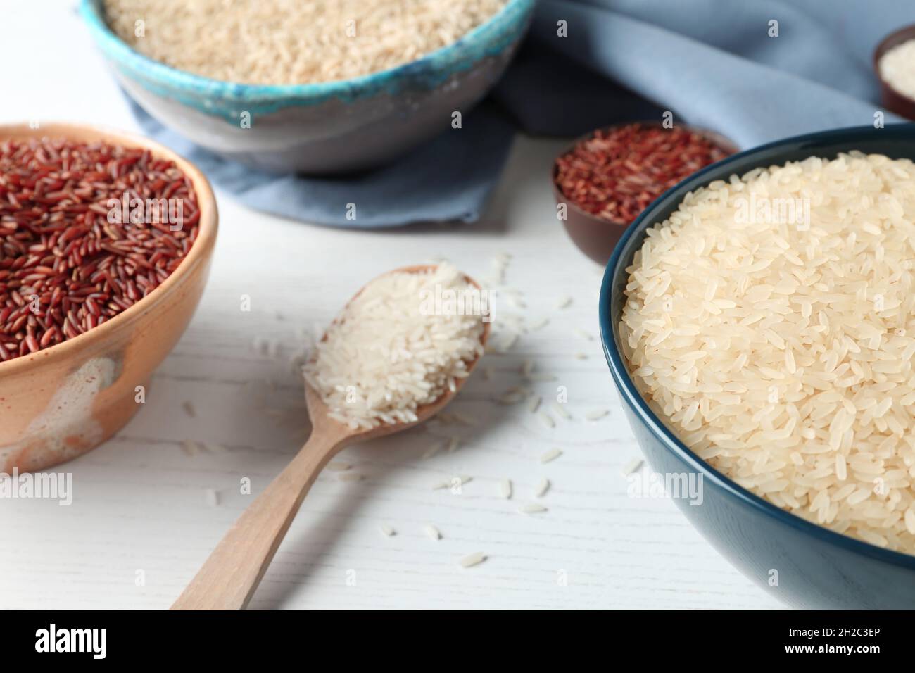 White Rice Compostition Composition with brown and other types of rice on white wooden ...