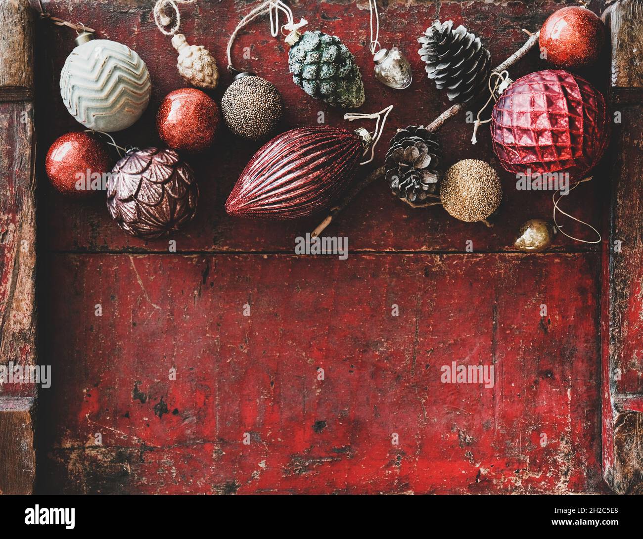 Flat-lay of Christmas decorative toys over red wooden background, top view Stock Photo