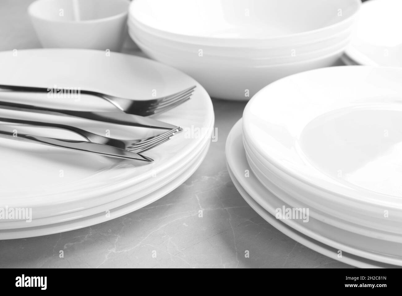 Many stacked plates with cutlery, closeup Stock Photo Alamy