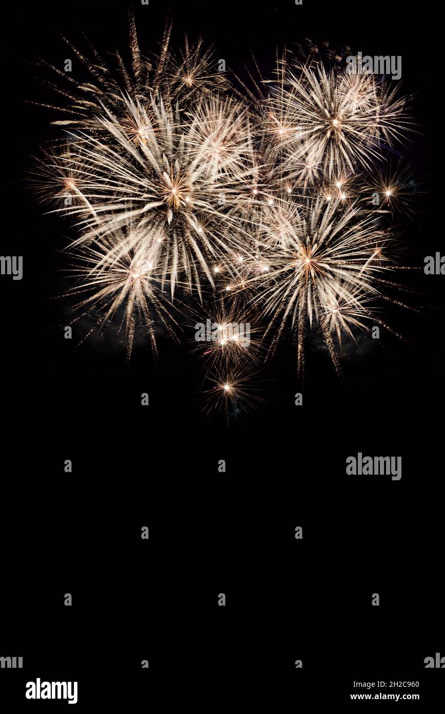 Fireworks display isolated on black with copy space. Pyrotechnic background for greeting card or festival celebration poster. Vertical format. Stock Photo