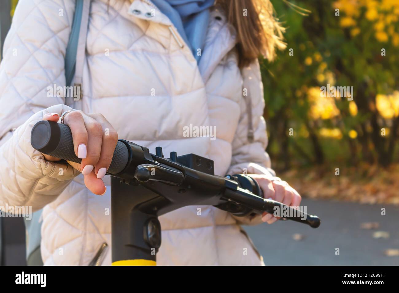 Woman on electric scooter in city. Close-up. Stock Photo