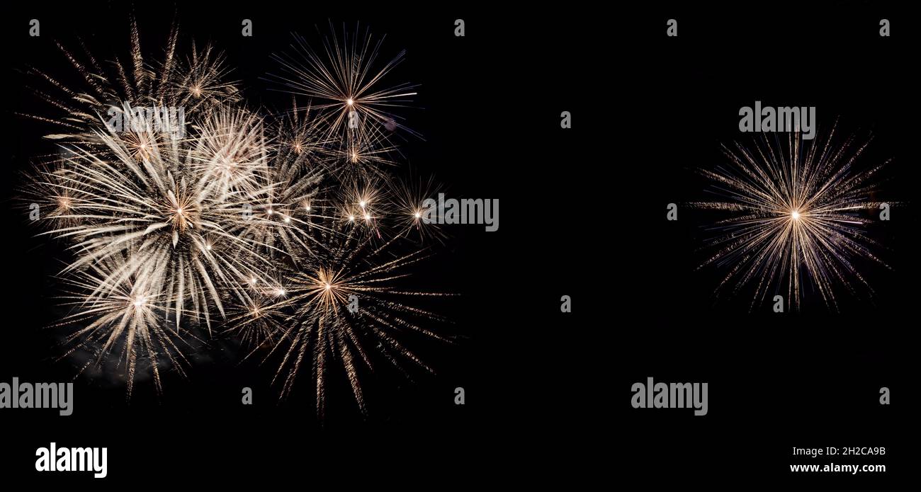 Fireworks display isolated on black with copy space. Pyrotechnic background for greeting card or festival celebration banner. Panoramic format Stock Photo