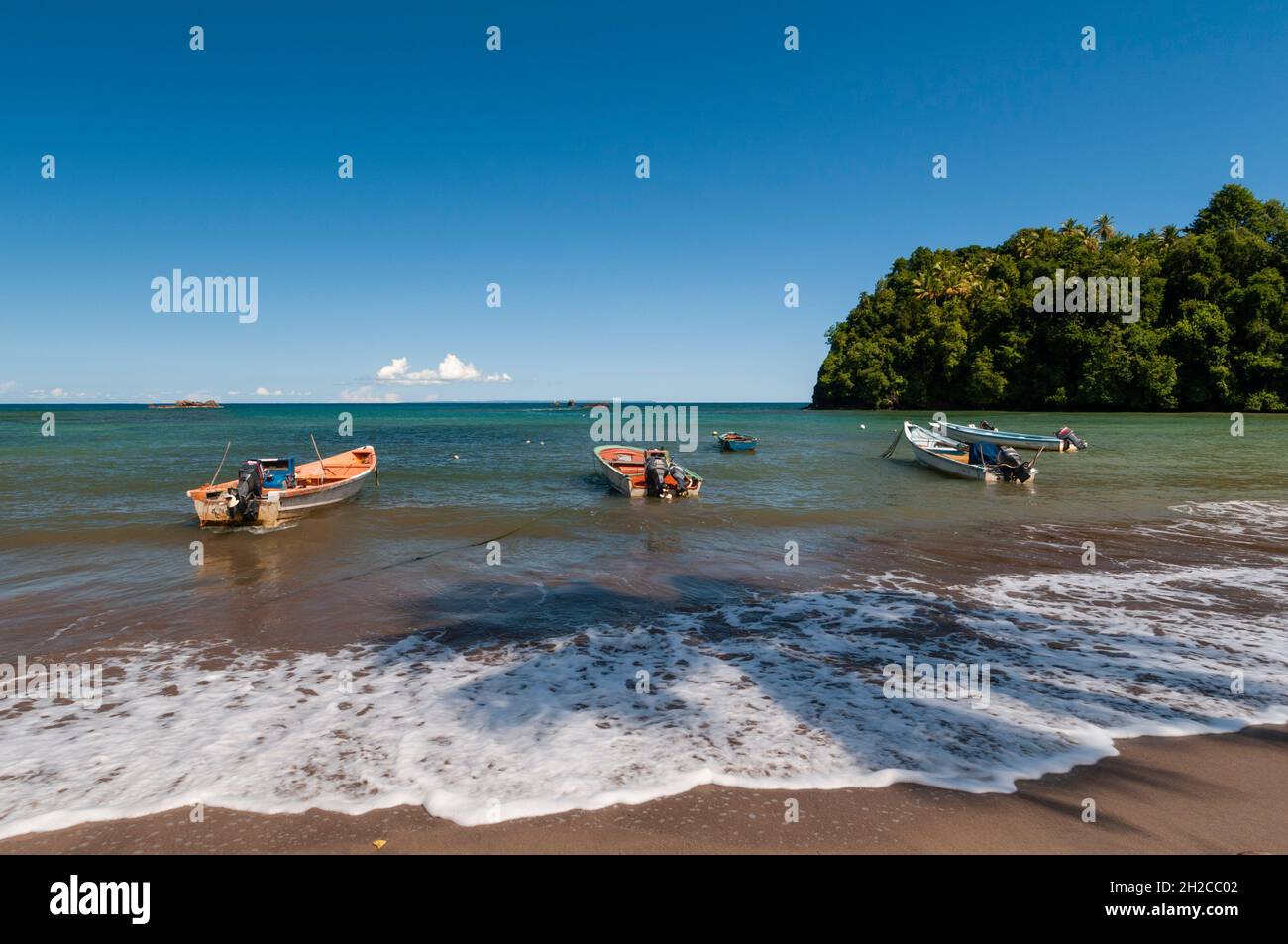 Fishing boats anchored in shallow water of Anse de Mai. Anse de Mai, Dominica, West Indies Stock