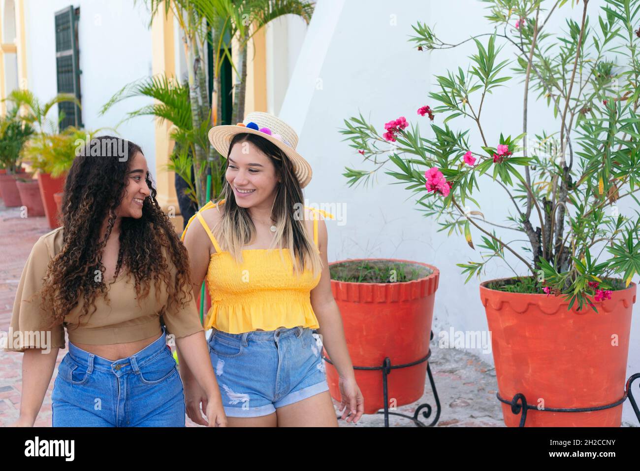 Two Girls Walking Down The Street Stock Photo - Alamy