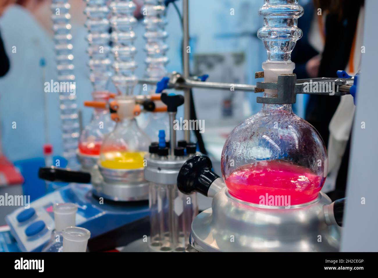 Laboratory equipment glass flask with multicolored liquid on heating